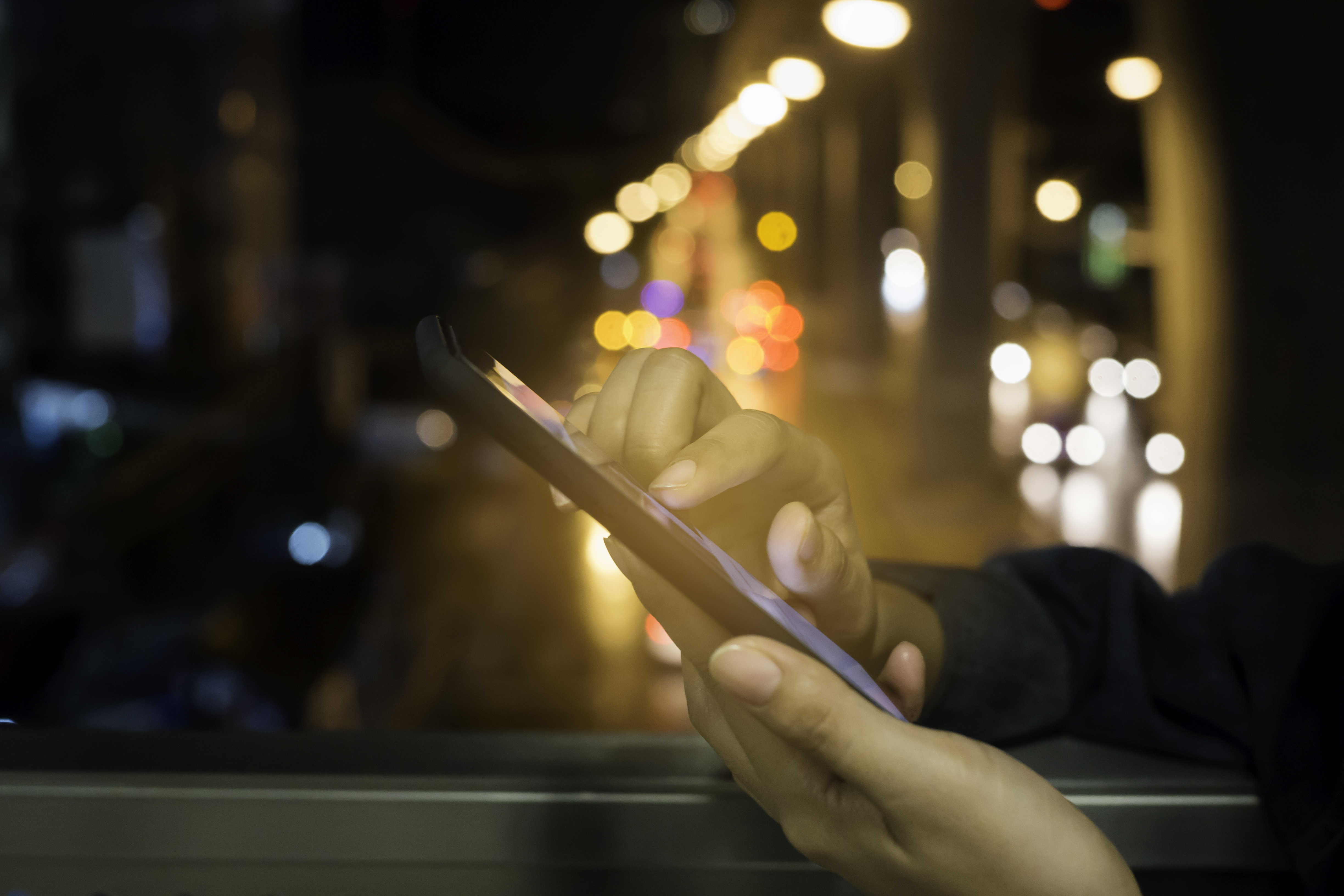 Woman  touch screen  smartphone on blurred night-lights